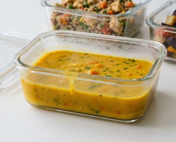 Creme dourado de legumes servido em recipiente de vidro